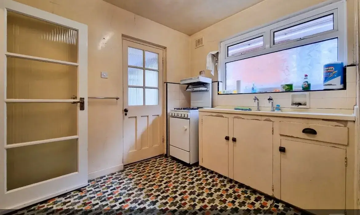 a kitchen with a sink, stove, and cabinets