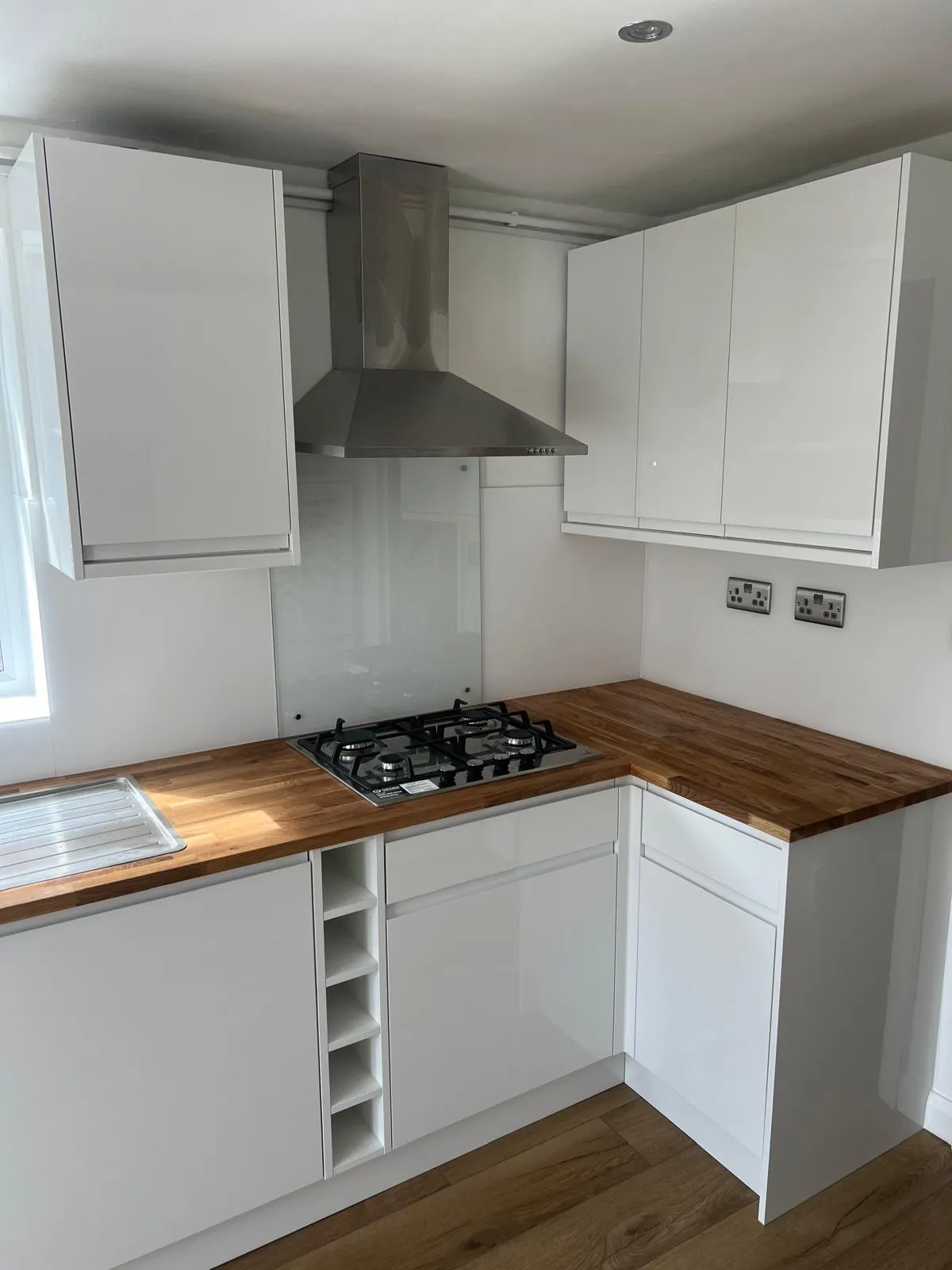 a kitchen with white cabinets and a wood counter top
